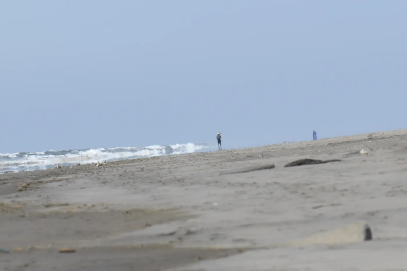 Beachcombers in the sea haze